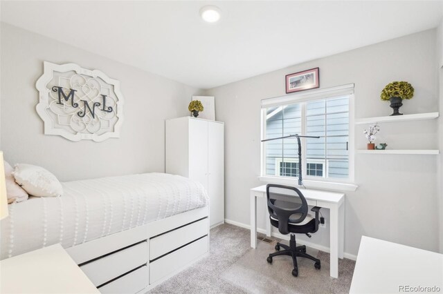 bedroom with light colored carpet and baseboards
