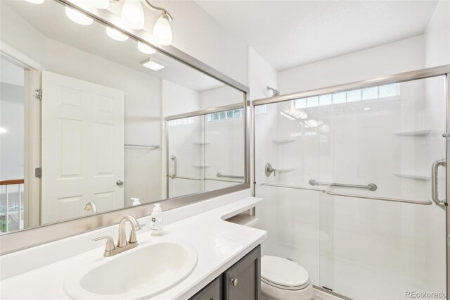 bathroom with vanity, toilet, and a stall shower
