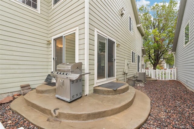 view of patio featuring a grill, central air condition unit, and fence
