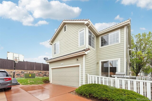 view of front of home with fence, a garage, and concrete driveway