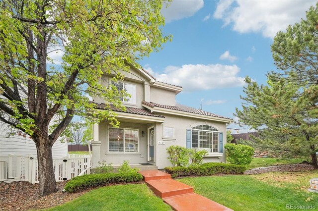 traditional home featuring stucco siding and a tile roof