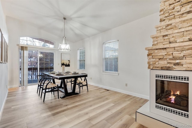 dining room with a fireplace and light hardwood / wood-style floors