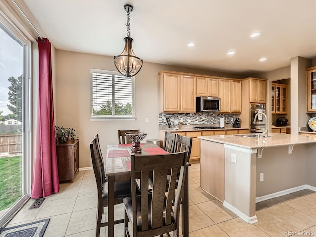 8522 S Dudley St, Littleton, CO 80128 - kitchen featuring stainless steel microwave, light brown cabinets, light tile patterned floors, tasteful backsplash, and recessed lighting