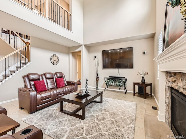 8522 S Dudley St, Littleton, CO 80128 - tiled living room featuring a high ceiling, stairs, and a stone fireplace