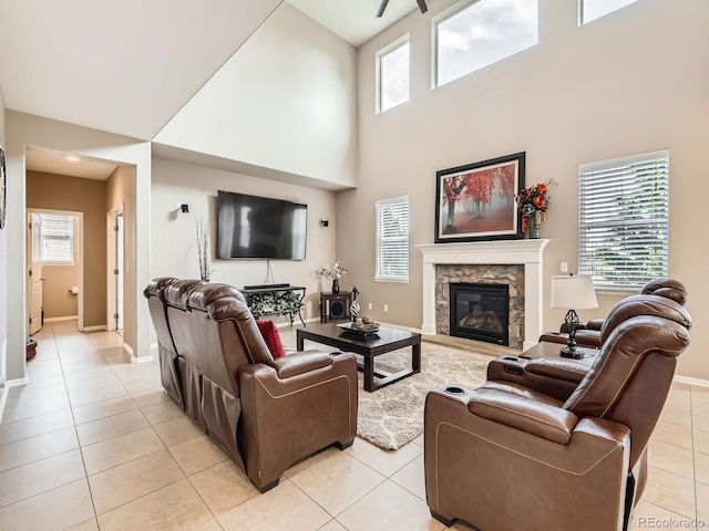 8522 S Dudley St, Littleton, CO 80128 - living room with light tile patterned flooring, a towering ceiling, a fireplace, and a ceiling fan