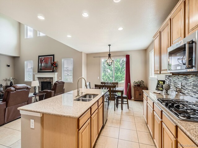 8522 S Dudley St, Littleton, CO 80128 - kitchen with appliances with stainless steel finishes, a glass covered fireplace, light tile patterned floors, open floor plan, and recessed lighting
