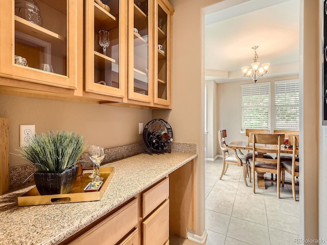 8522 S Dudley St, Littleton, CO 80128 - kitchen featuring light tile patterned flooring, a chandelier, light stone countertops, and glass insert cabinets