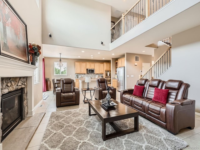 8522 S Dudley St, Littleton, CO 80128 - living area with a towering ceiling, light tile patterned floors, stairs, and a stone fireplace
