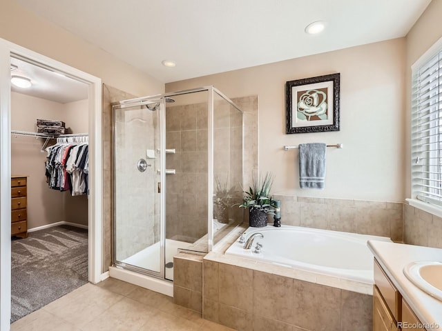 8522 S Dudley St, Littleton, CO 80128 - full bathroom featuring a bath, a stall shower, tile patterned flooring, a spacious closet, and recessed lighting