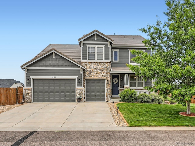 8522 S Dudley St, Littleton, CO 80128 - craftsman-style house featuring stone siding, concrete driveway, covered porch, an attached garage, and a tile roof