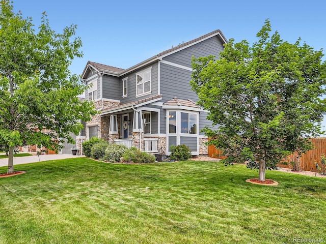 8522 S Dudley St, Littleton, CO 80128 - view of front of house with stone siding, a porch, and a garage