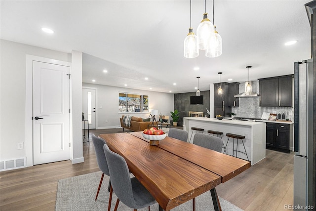 dining area with recessed lighting, baseboards, visible vents, and light wood finished floors