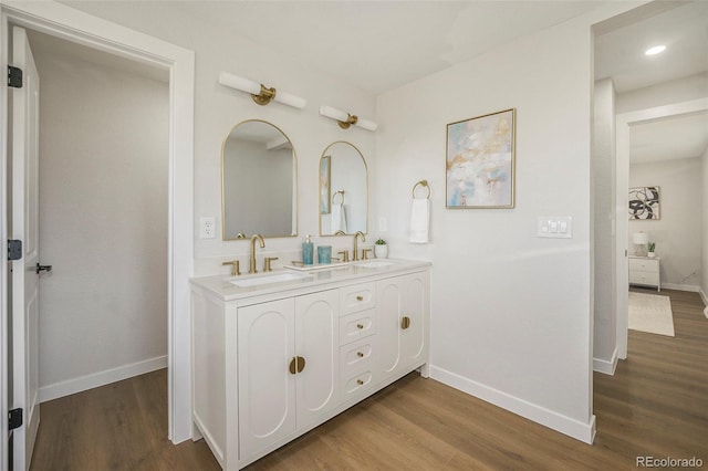 bathroom with baseboards, a sink, and wood finished floors