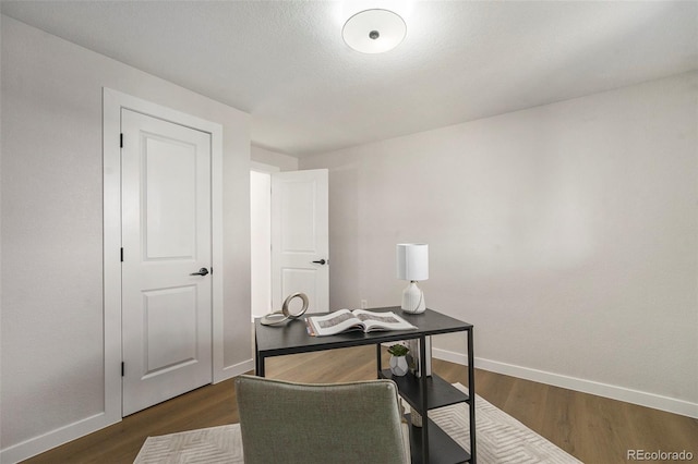 home office featuring baseboards and dark wood-type flooring