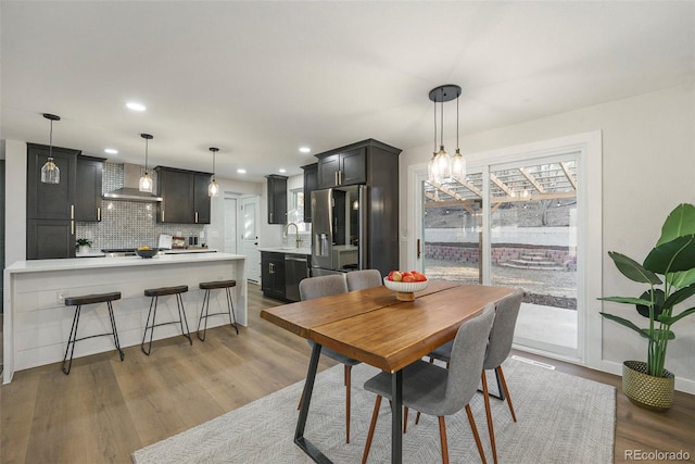 dining area with wood finished floors and recessed lighting