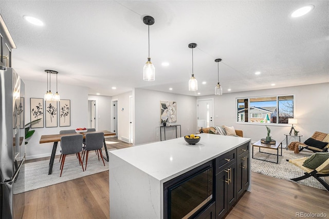 kitchen with open floor plan, wood finished floors, and freestanding refrigerator