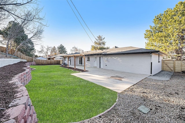 rear view of property featuring a patio, brick siding, and a fenced backyard