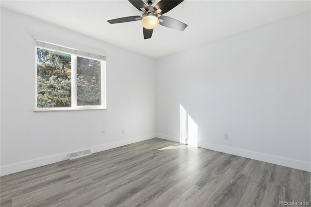 spare room featuring hardwood / wood-style flooring, ceiling fan, and a textured ceiling