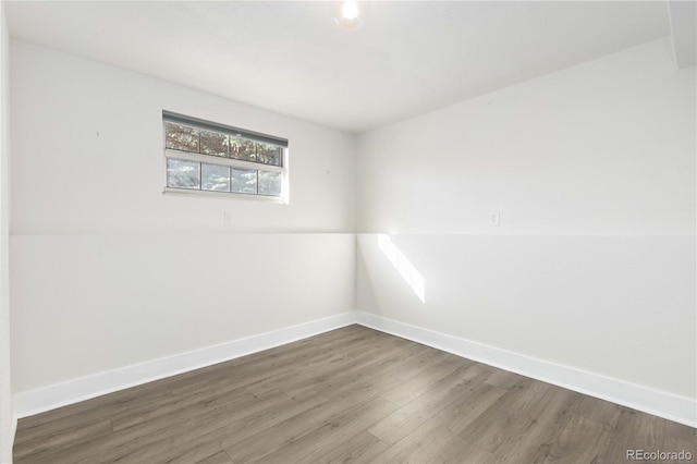 unfurnished room with dark wood-type flooring and vaulted ceiling