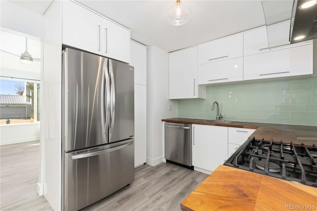 kitchen with white cabinetry, appliances with stainless steel finishes, and wooden counters