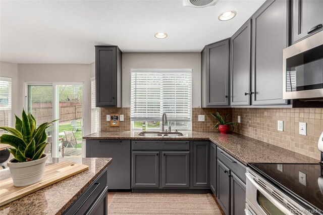 4873 S Fultondale Way, Aurora, CO 80016 - kitchen with appliances with stainless steel finishes, a sink, dark stone countertops, gray cabinets, and recessed lighting