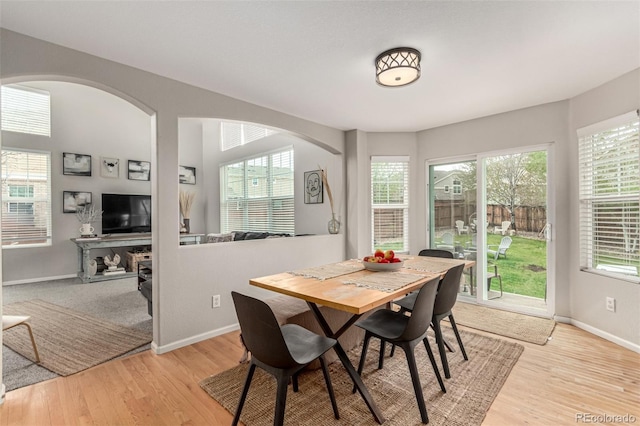 4873 S Fultondale Way, Aurora, CO 80016 - dining space with arched walkways, light wood-style flooring, and baseboards