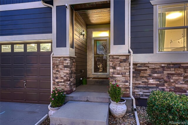 25 N Irvington St, Aurora, CO 80018 - view of exterior entry featuring stone siding and a garage