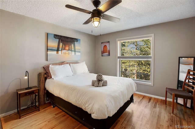 bedroom with ceiling fan, a textured ceiling, and light wood-type flooring