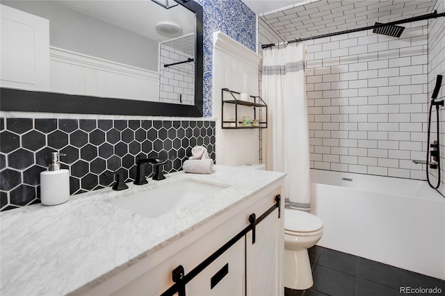 full bathroom with tasteful backsplash, shower / bath combination with curtain, toilet, vanity, and tile patterned floors