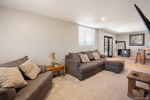 carpeted living room with a wood stove