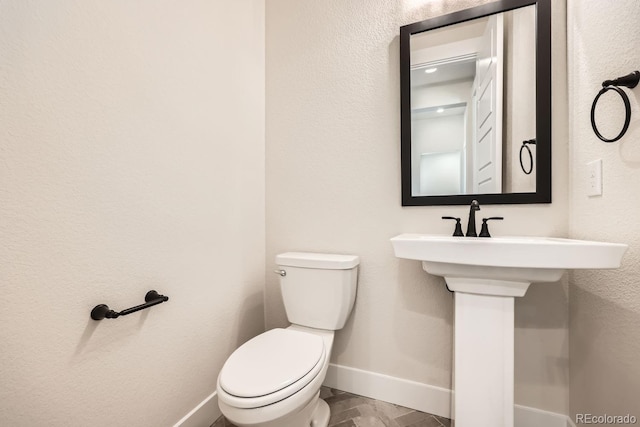 bathroom featuring toilet and baseboards