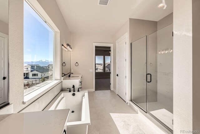 bathroom featuring plenty of natural light, a shower stall, visible vents, and baseboards