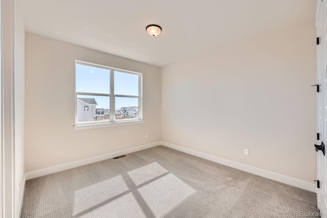 unfurnished room featuring light colored carpet, visible vents, and baseboards