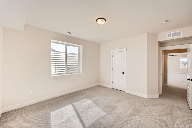 unfurnished bedroom with light carpet, visible vents, and baseboards