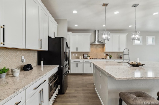 kitchen featuring wall chimney exhaust hood, dark hardwood / wood-style flooring, tasteful backsplash, and pendant lighting