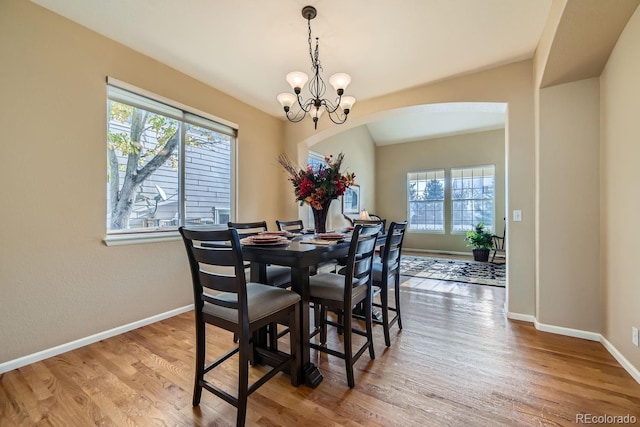 dining area featuring hardwood / wood-style floors, plenty of natural light, and a notable chandelier