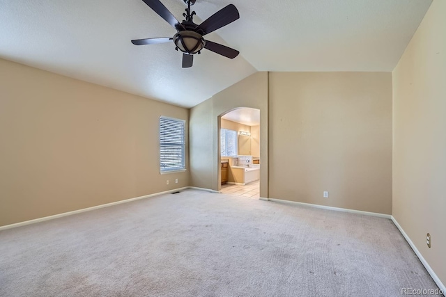 carpeted spare room with ceiling fan and lofted ceiling