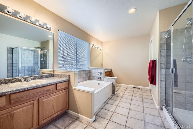 bathroom with tile patterned flooring, a textured ceiling, vanity, and separate shower and tub