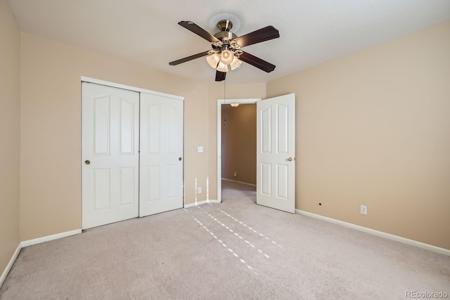 unfurnished bedroom with light colored carpet, a closet, and ceiling fan