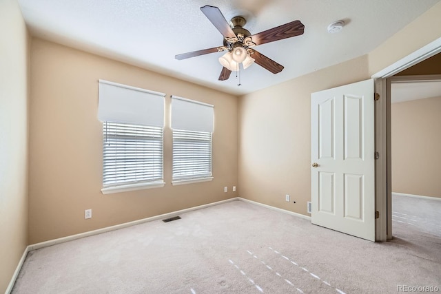 carpeted spare room featuring ceiling fan