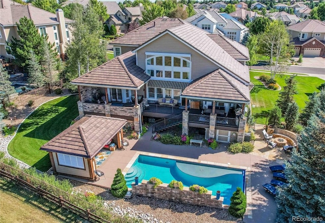 back of house featuring a fenced in pool, a patio area, and a lawn