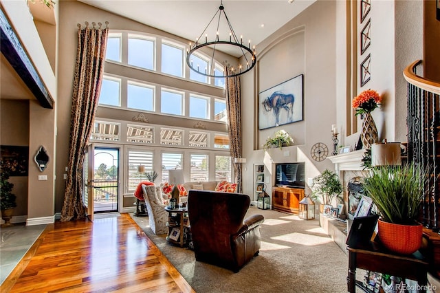 living room featuring an inviting chandelier, a high ceiling, and hardwood / wood-style flooring