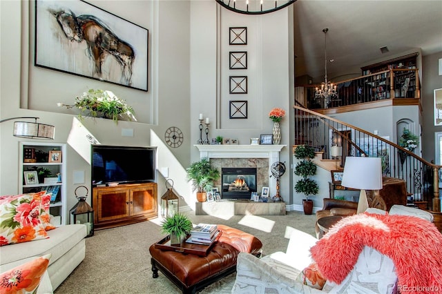 living room featuring a notable chandelier, a tiled fireplace, and carpet flooring