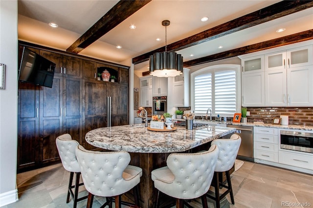 kitchen with white cabinetry, a center island, pendant lighting, decorative backsplash, and appliances with stainless steel finishes