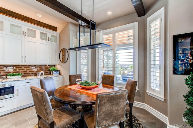 dining area featuring beam ceiling