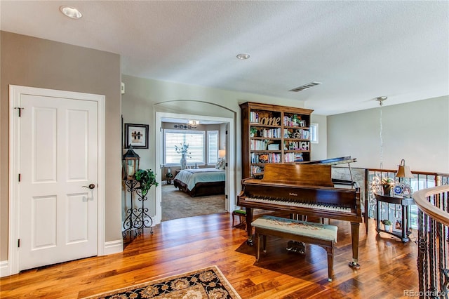 misc room featuring wood-type flooring, a textured ceiling, and an inviting chandelier