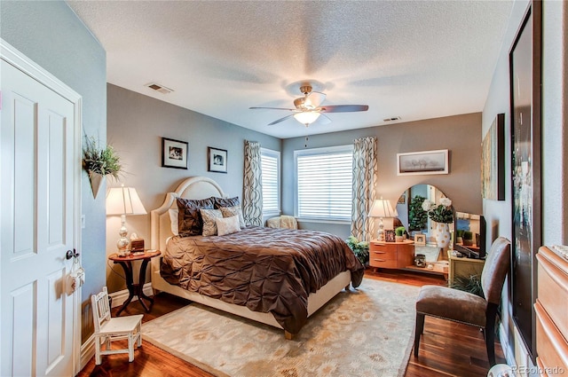 bedroom featuring wood-type flooring, a textured ceiling, and ceiling fan