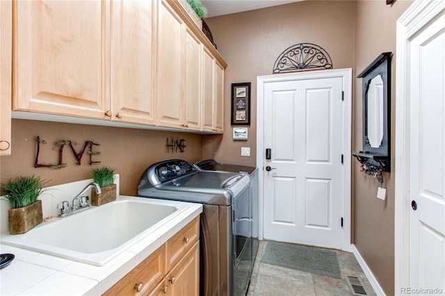 washroom featuring separate washer and dryer, sink, and cabinets