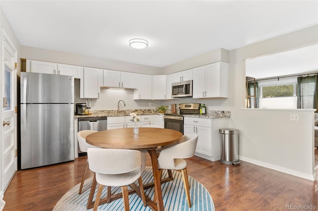 8485 W 44th Ave, Wheat Ridge, CO 80033 - kitchen with stainless steel appliances, dark wood-style flooring, and white cabinetry