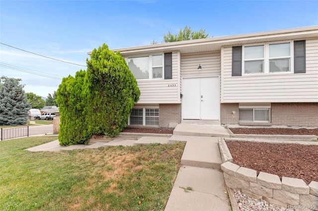 8485 W 44th Ave, Wheat Ridge, CO 80033 - raised ranch featuring brick siding and a front lawn